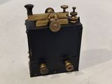 an old fashioned black and gold clock sitting on top of a white table