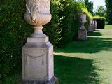 a stone urn in the middle of a grassy area