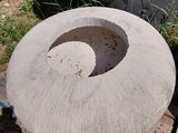 a concrete bowl sitting on a pallet next to a building