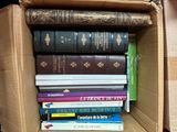 une boîte remplie de livres empilés les uns sur les autres