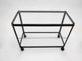 an image of a glass and metal bar cart on wheels
