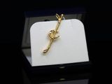 a gold brooch in a black box on a black surface
