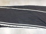 a black towel with white stripes on it on the floor