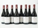 six bouteilles de vin rouge sont alignées sur une surface blanche