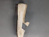pair of white slippers on a gray surface with a black strap
