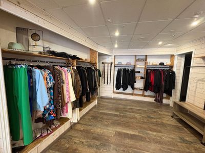 a photo of a clothing store with a lot of clothes on the racks