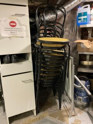 une pile de chaises et un réfrigérateur dans une pièce