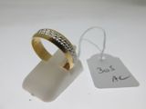 une bague en or sertie de diamants, à côté d'une étiquette de prix