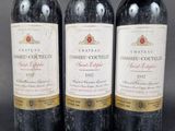three bottles of red wine sitting next to each other on a table