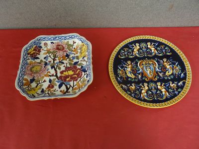 two plates with floral designs on them sitting on a red table