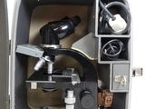 an open box with a microscope and other items in it