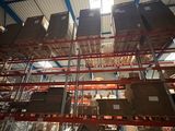 boxes are stacked on a rack in a warehouse with the sun shining through the roof