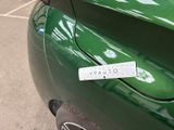 a green car with a sticker on the side of it