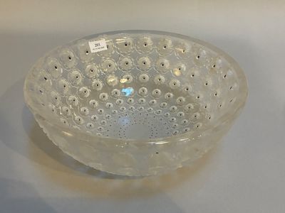 un saladier en verre percé de trous posé sur une table