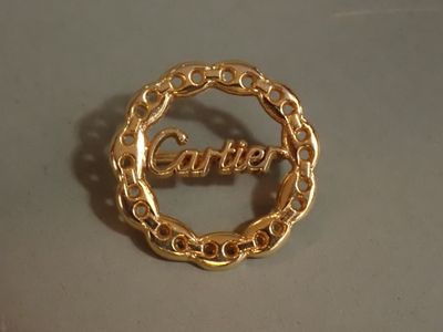 un gros plan d'une bague en or sur laquelle est gravé le mot « Carrie »