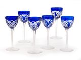 six blue wine glasses are lined up in a row on a white surface