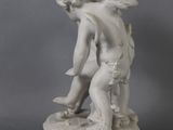 statue of a boy with a bird on a pedestal on a gray background