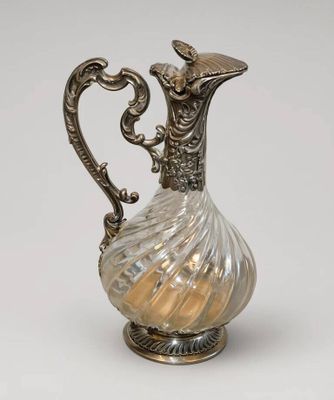 un pichet ancien en argent et en verre sur fond blanc