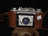 a brown leather case with a camera on top of it