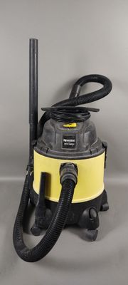 un gros plan d'un aspirateur à eau jaune et noir posé sur une surface grise