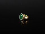une bague en or avec une pierre verte au centre
