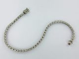 a close up of a silver bracelet with a clasp on a white surface