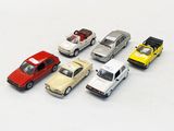 several toy cars are lined up in a row on a white surface