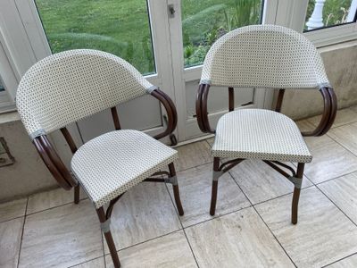 two chairs sitting next to each other in front of a window