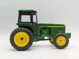 a toy tractor that is sitting on a white surface