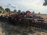 a tractor that is parked in a field with a plow behind it