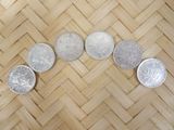 four silver coins sitting on top of a wooden floor next to each other