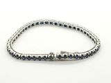 un gros plan d'un bracelet orné de pierres bleues sur un fond blanc