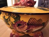 un bol jaune orné d'un poisson, posé sur une table