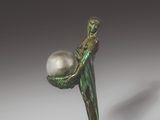 an image of a statue of a man holding a ball on a rope
