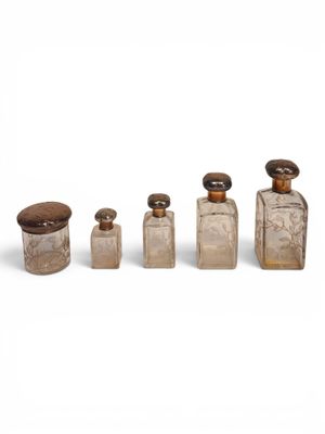 four glass bottles with wooden lids and lids on a white surface