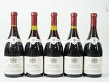 six bouteilles de vin sont alignées sur une surface blanche