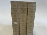 three books sitting on top of each other on a white surface