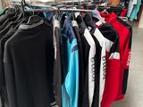 beaucoup de vêtements suspendus à une étagère dans un magasin