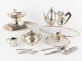 un ensemble d'objets en métal argenté comprenant une théière, une soucoupe, des cuillères et des ustensiles
