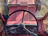 a man sitting in a red tractor with a steering wheel