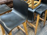 quatre chaises en cuir noir sont empilées dans un magasin
