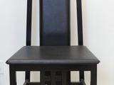 a black chair with a black seat on a white floor