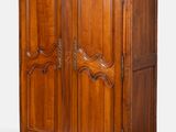 une armoire ancienne en bois, avec un dessus sculpté et deux portes