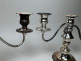 two silver candlesticks that are sitting on a table