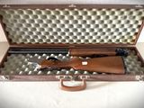 une mallette en bois contenant un fusil, posée sur une table