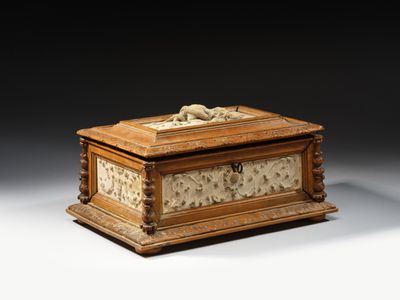 une vieille boîte en bois sculptée posée sur une table