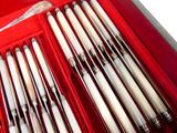 une boîte rouge remplie d'ustensiles argentés et blancs