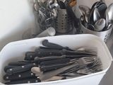 un saladier posé sur un plan de travail de cuisine, contenant des ustensiles