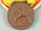 an image of a medal with a red and yellow ribbon around it