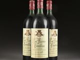 three bottles of wine sit on a table with a black background